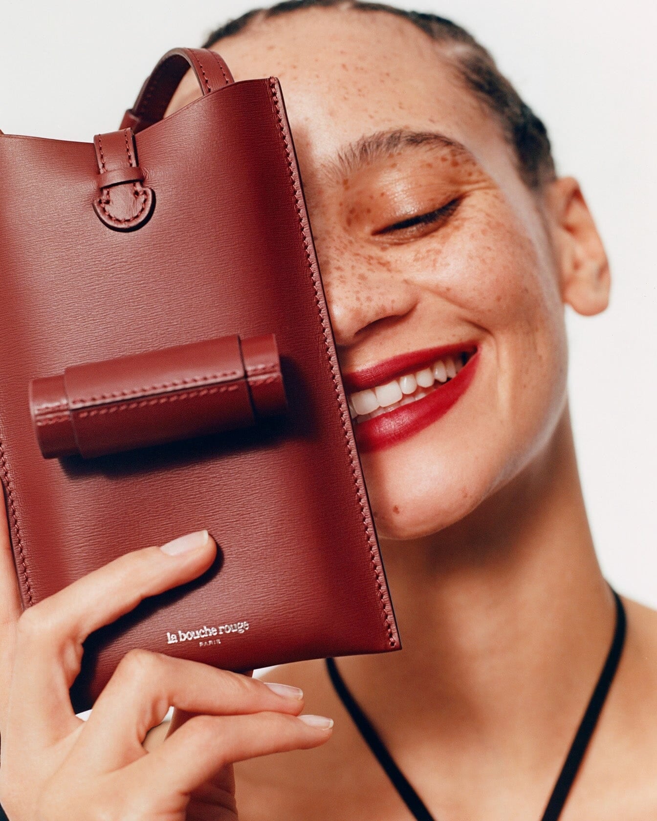 Sac 21 La Bouche Rouge Paris en cuir noir avec fermeture métallique élégante, vue en angle sur fond blanc.