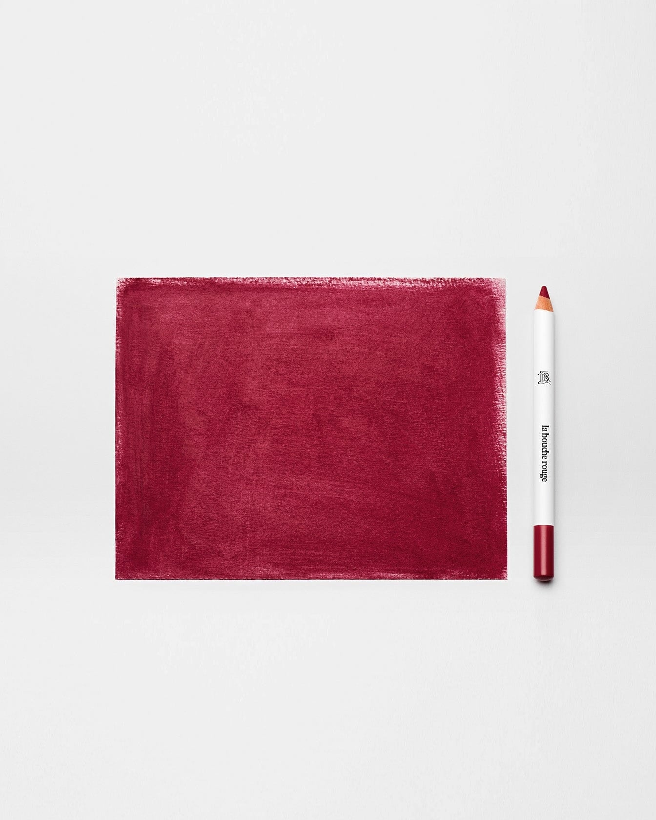 Crayon à lèvres Bordeaux de La Bouche Rouge Paris avec mine colorée et emballage élégant sur fond neutre.