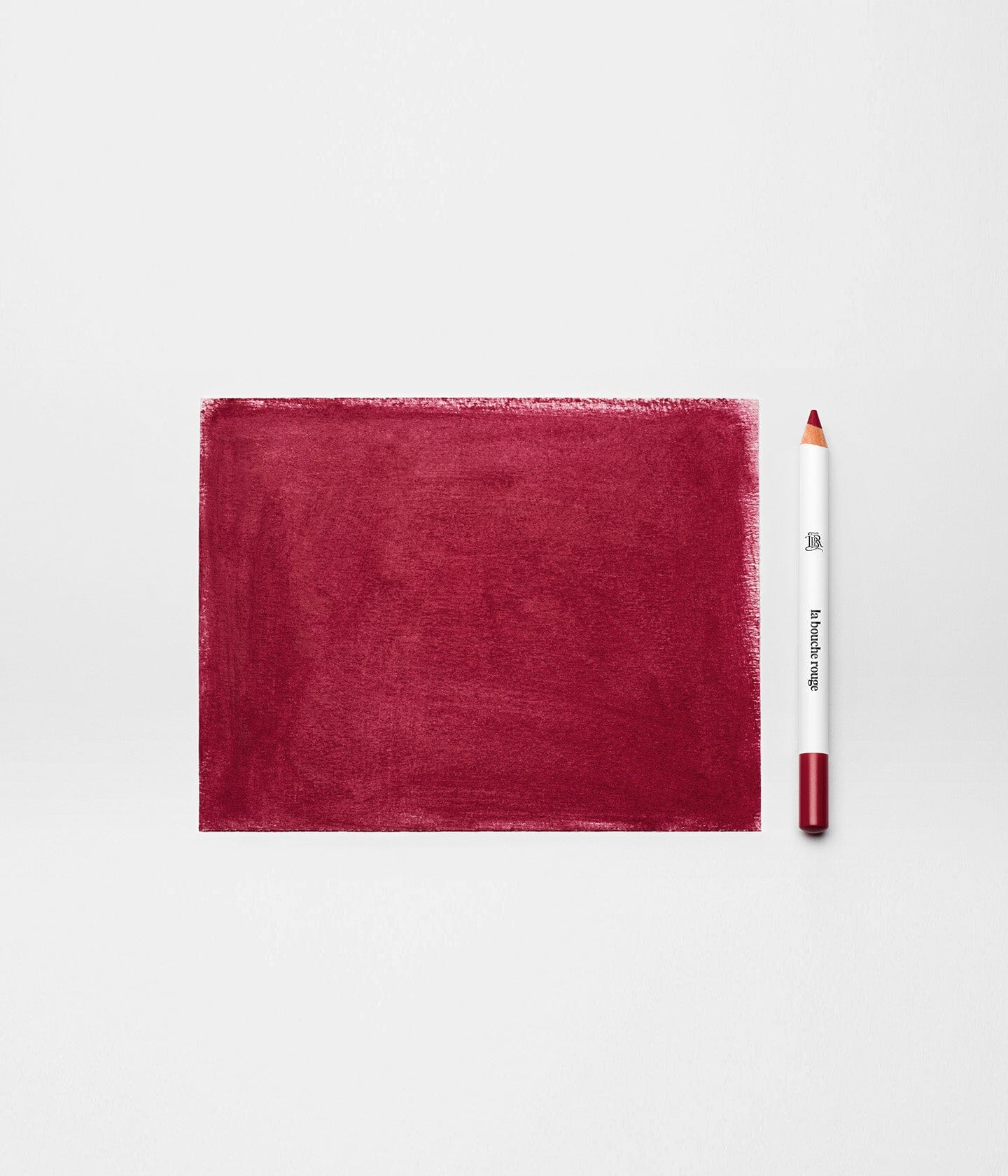 Crayon à lèvres Bordeaux de La Bouche Rouge Paris avec mine colorée et emballage élégant sur fond neutre.