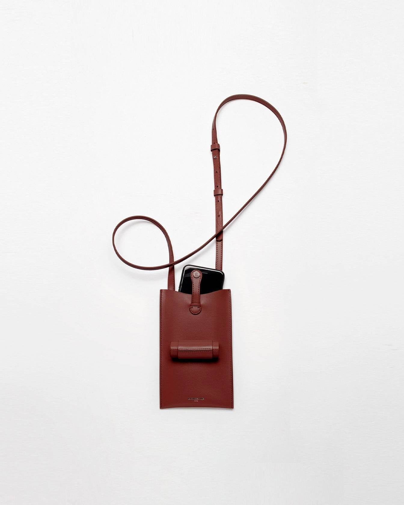Sac 21 La Bouche Rouge Paris en chocolat avec téléphone dans son écrin rechargeable, vue de face dans une image claire.