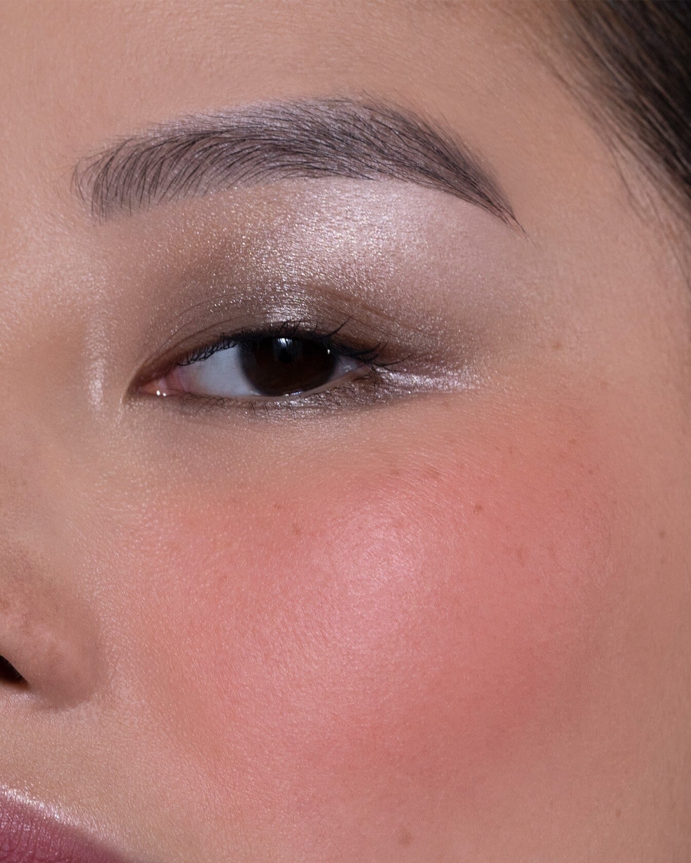 Blush solaire La Bouche Rouge Paris en teinte abricot et corail, présenté sur un bureau, avec packaging élégant.