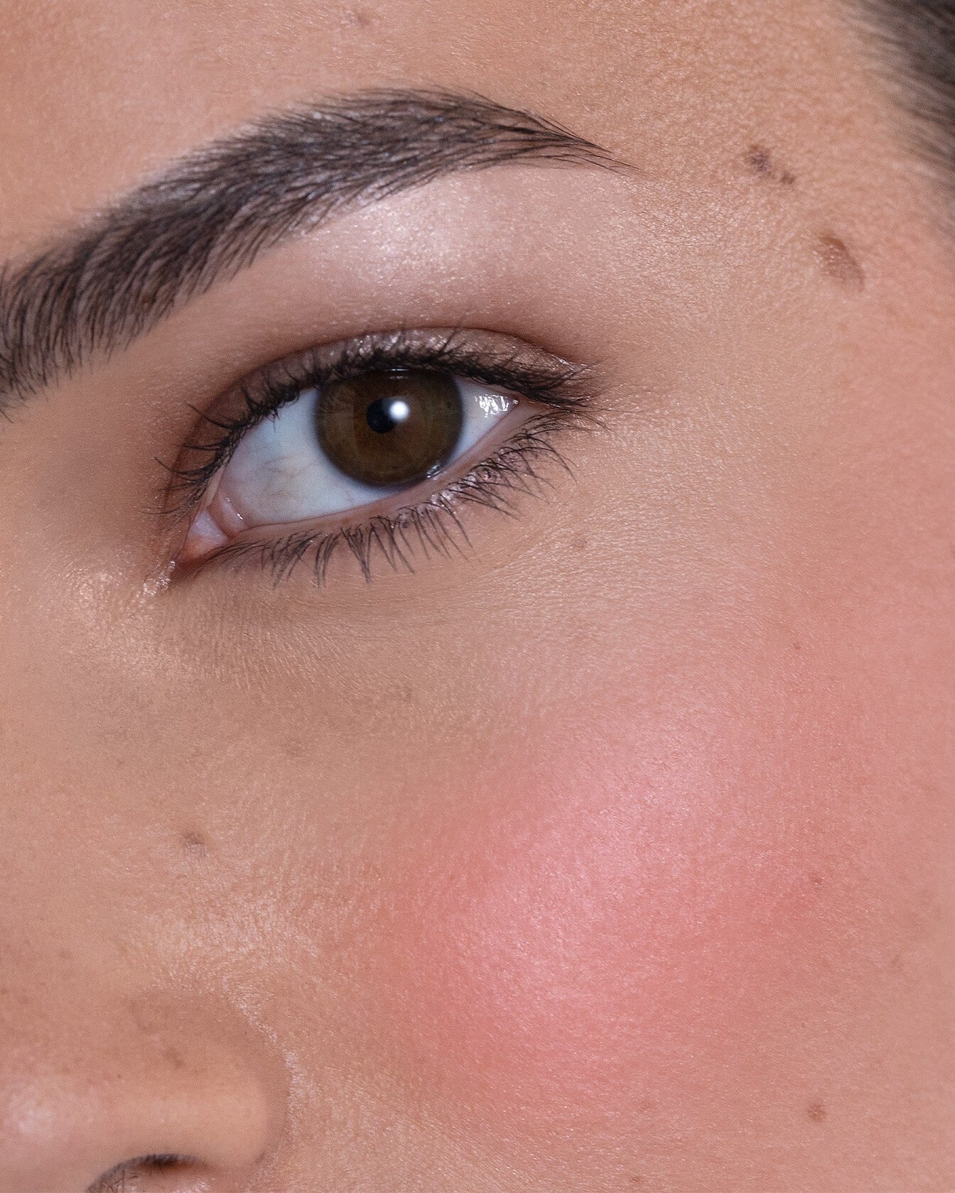 Accord lumineux Rose Pop et Dewy Pink de La Bouche Rouge Paris, blush crème sur un bureau avec un pinceau.