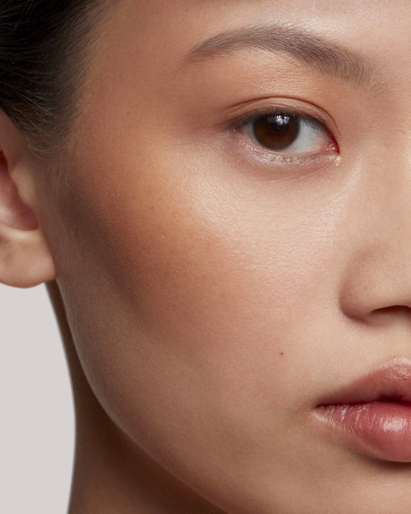 Poudre de soleil La Bouche Rouge Paris appliquée sur le visage, bronzage naturel et éclat lumineux.