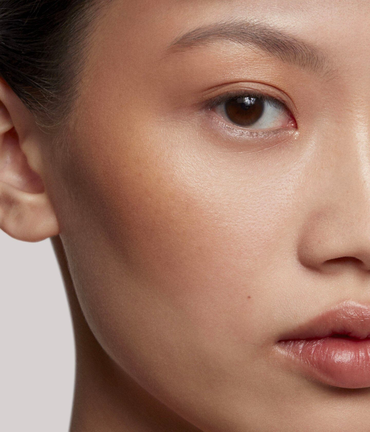 Poudre de soleil La Bouche Rouge Paris appliquée sur le visage, bronzage naturel et éclat lumineux.
