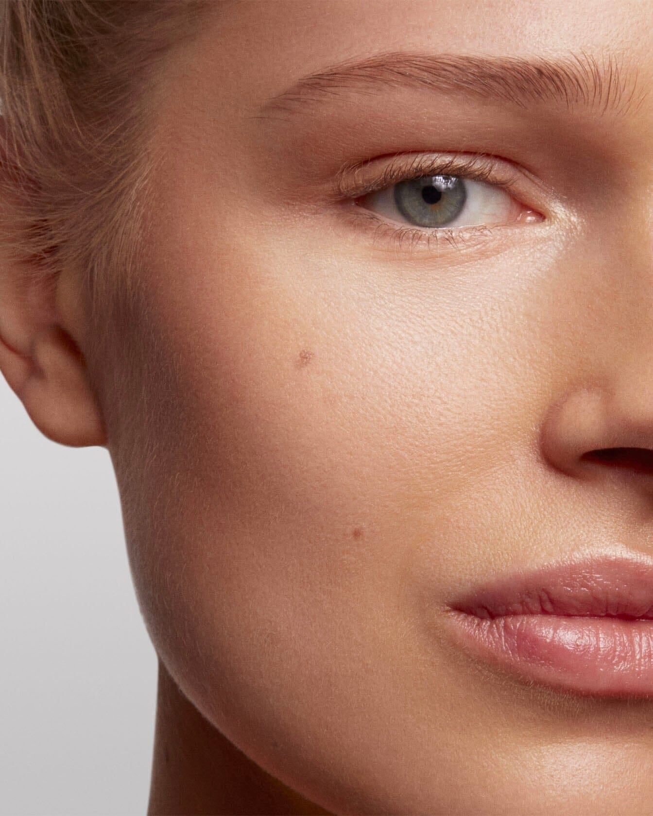 Poudre de soleil La Bouche Rouge Paris appliquée sur le visage, mettant en valeur un teint bronzé et lumineux.