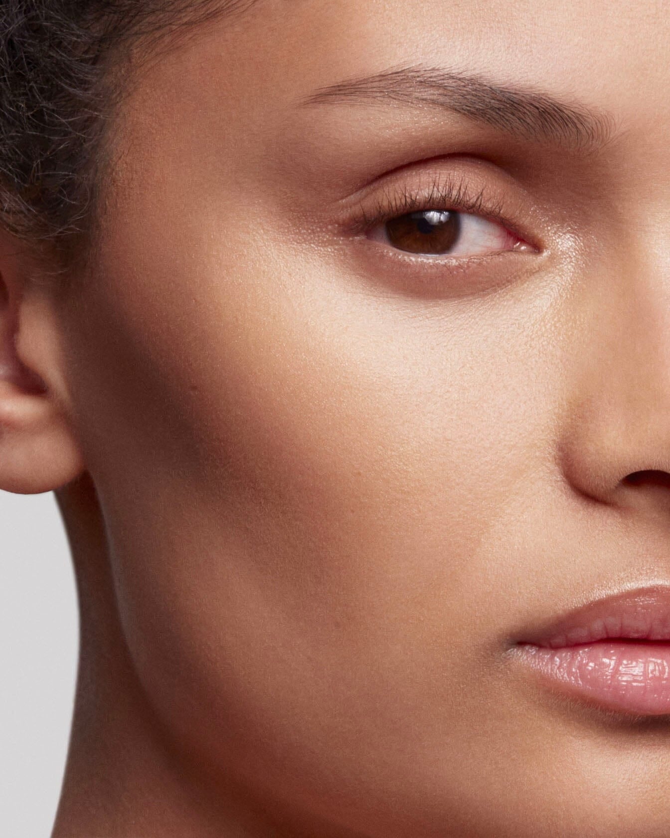 Poudre de soleil La Bouche Rouge Paris appliquée sur le visage, bronzage naturel et éclat lumineux.