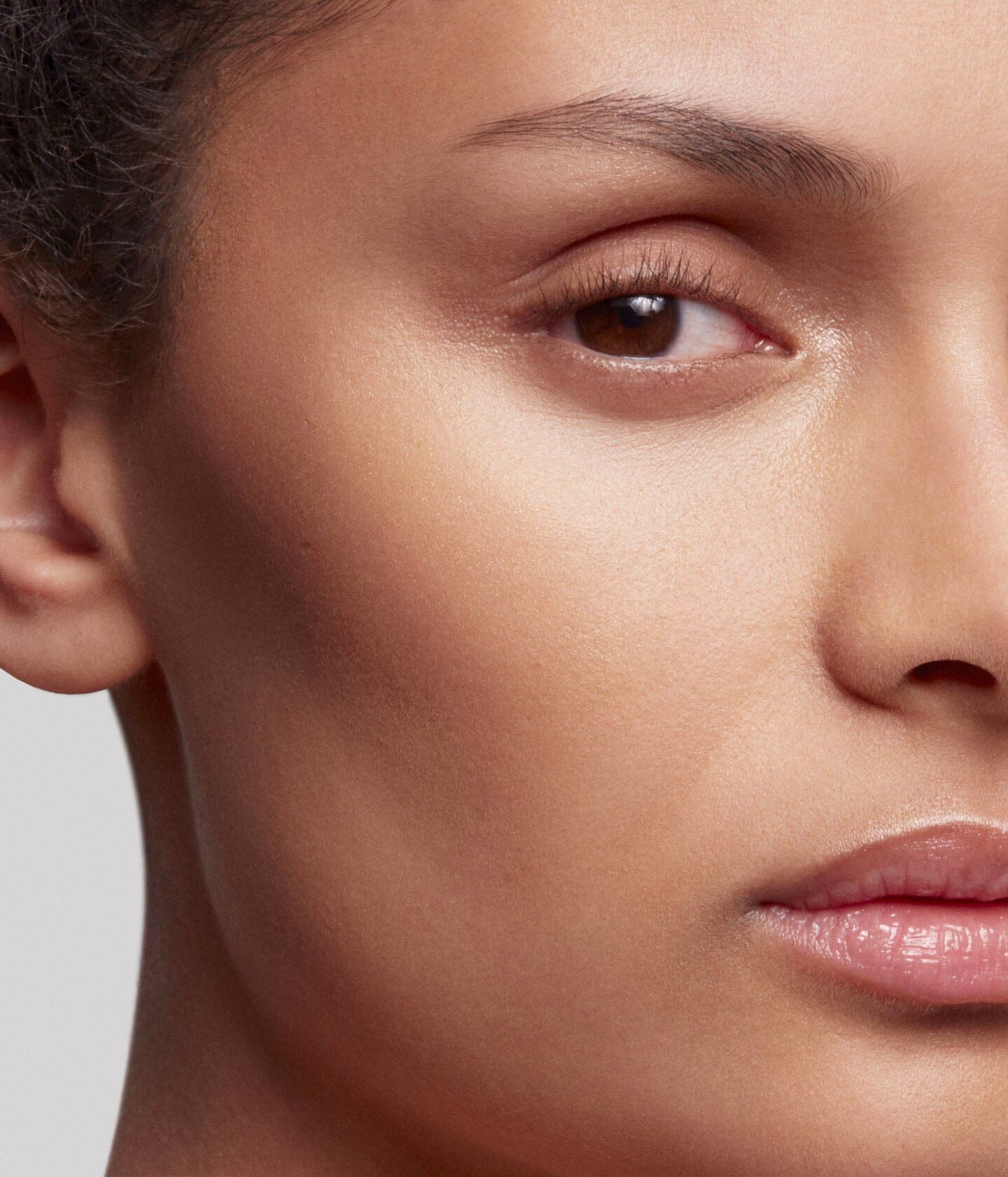 Poudre de soleil La Bouche Rouge Paris appliquée sur le visage, bronzage naturel et éclat lumineux.