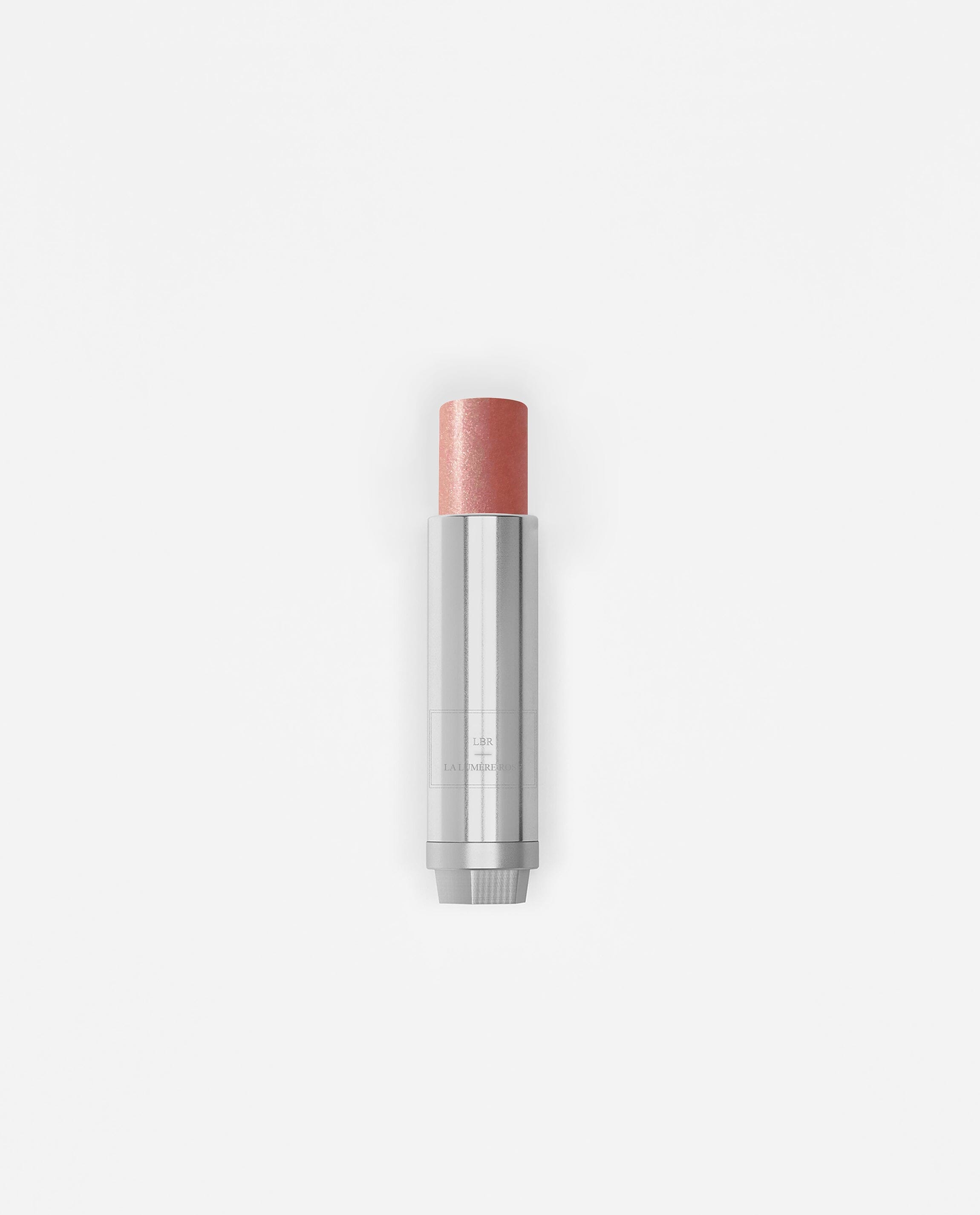 Stick enlumineur La Bouche Rouge Paris avec teinte rose, appliqué sur la peau pour un éclat naturel et lumineux.