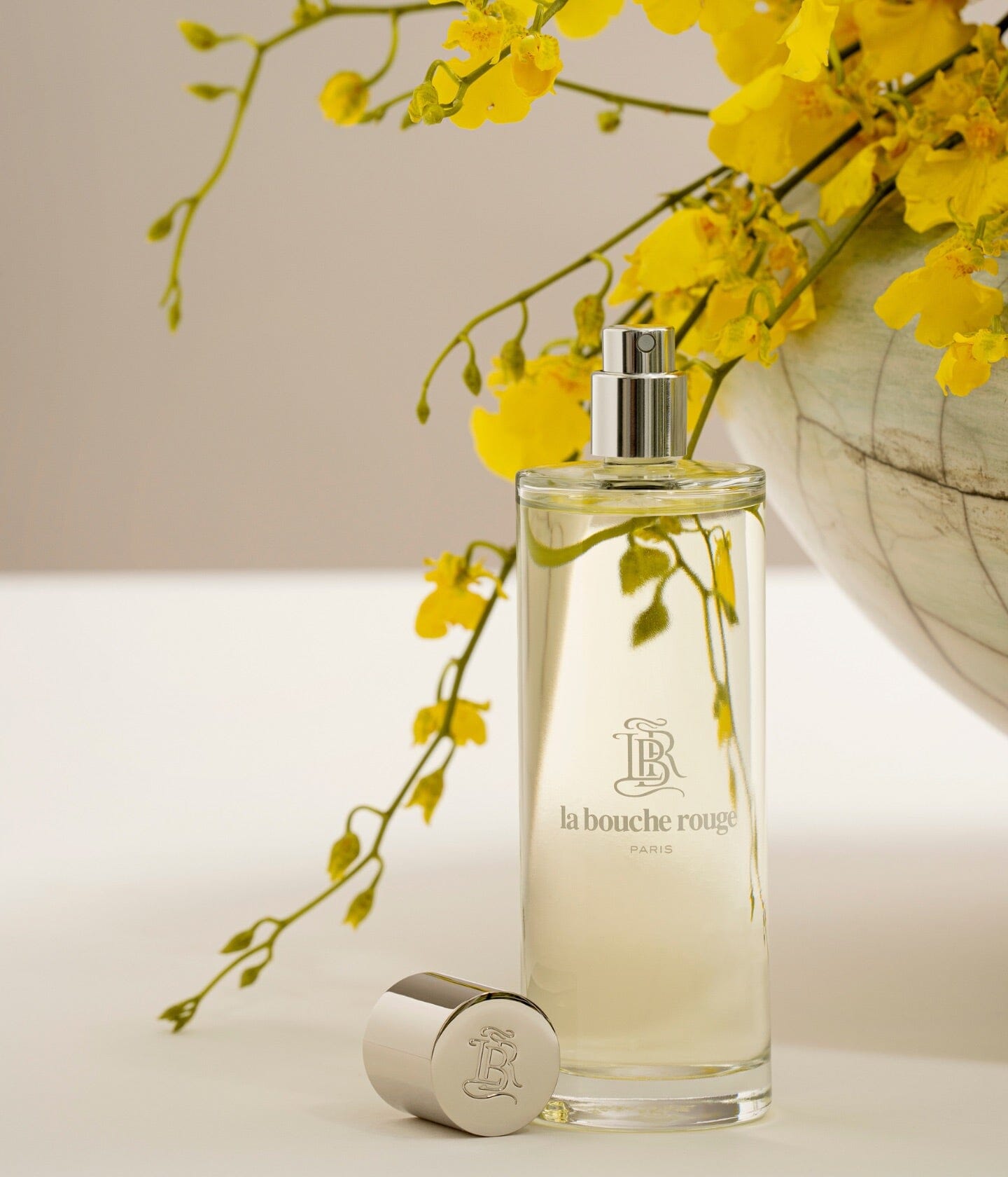 Flacon de parfum Capri Lumière Jaune de La Bouche Rouge Paris avec design élégant, visible dans une image lumineuse et sophistiquée.