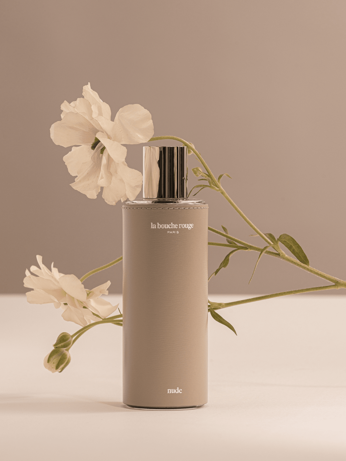 Extrait de parfum Nude de La Bouche Rouge Paris en flacon de 100 ml, gainé de cuir beige et composition florale