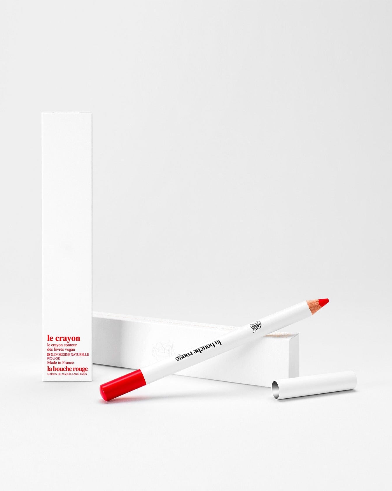Crayon à lèvres La Bouche Rouge Paris en teinte orange, avec une mine bien taillée, posé sur une surface claire.