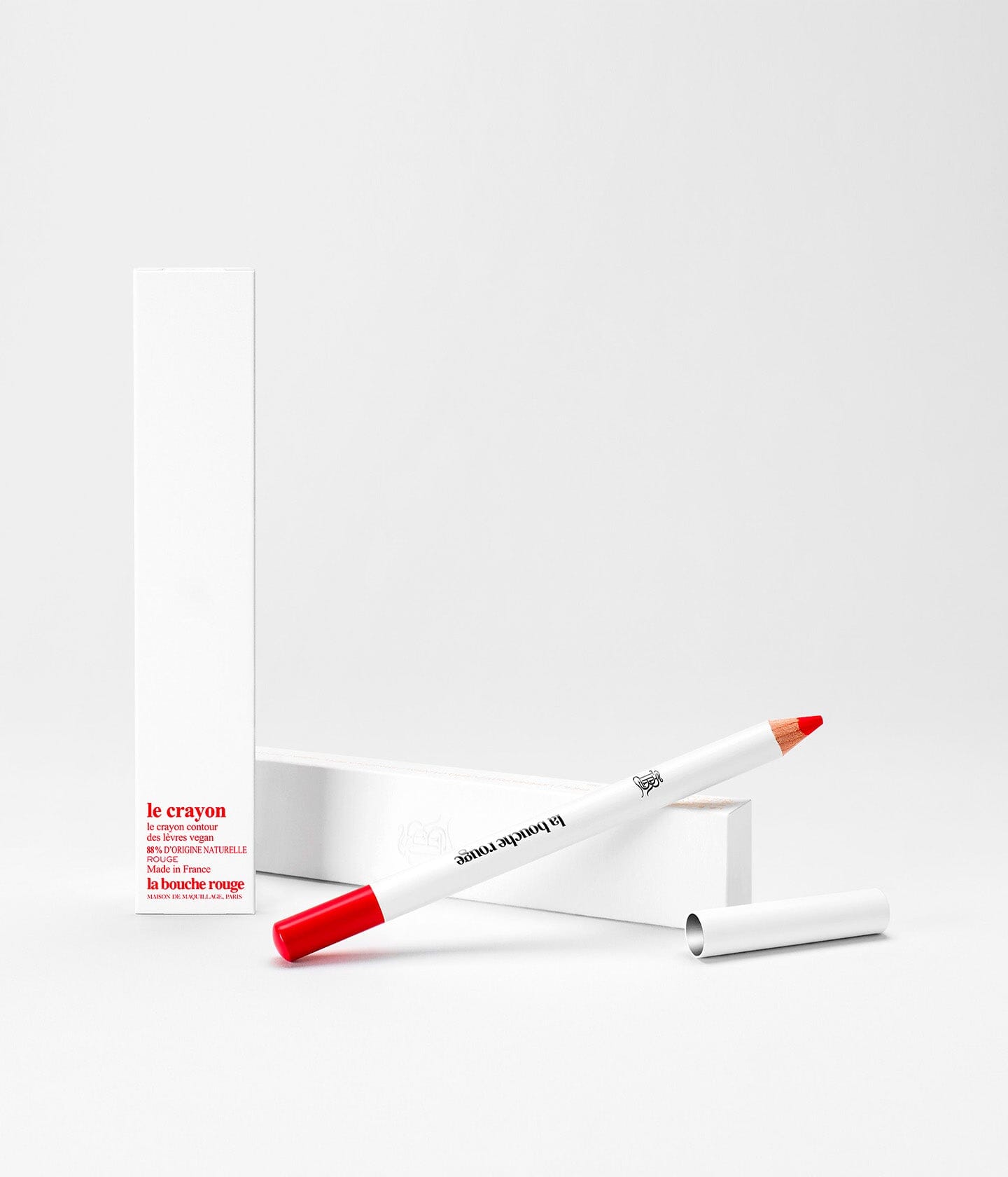Crayon à lèvres La Bouche Rouge Paris en teinte orange, avec une mine bien taillée, posé sur une surface claire.