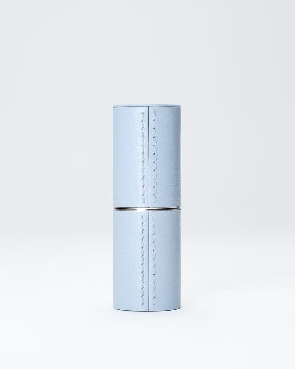 Étui rechargeable en cuir bleu de La Bouche Rouge Paris, élégant et compact pour ranger des produits de beauté.