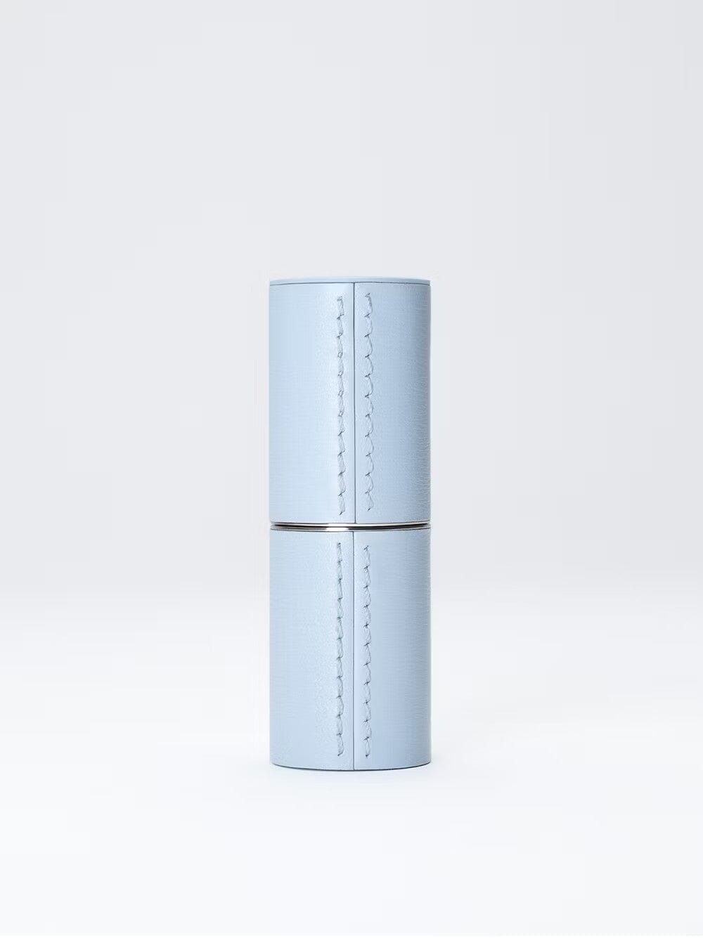 Étui rechargeable en cuir bleu de La Bouche Rouge Paris, élégant et compact pour ranger des produits de beauté.