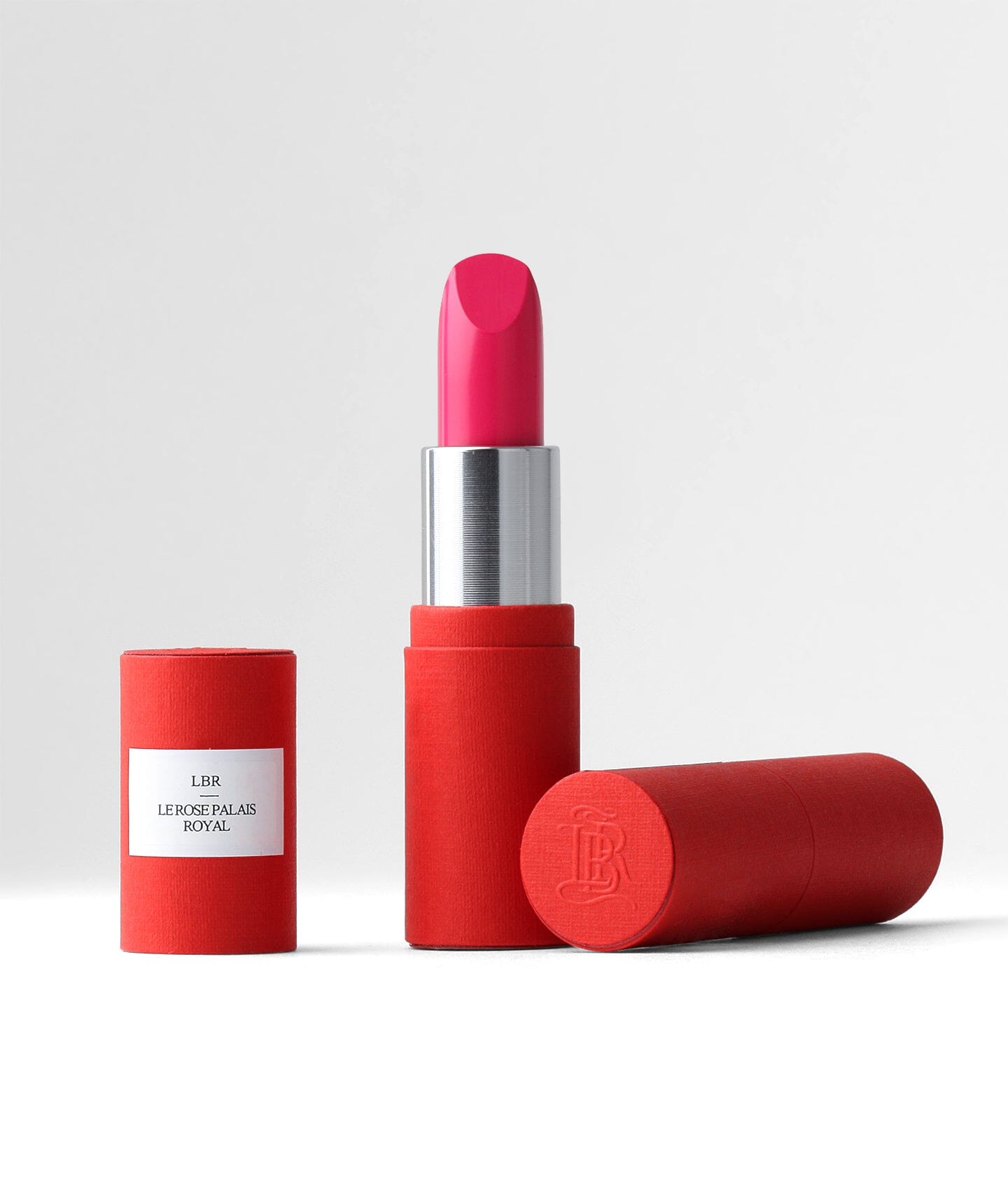 Rouge à lèvres La Bouche Rouge Paris dans un étui élégant, posé sur un fond évoquant Paris avec une recharge rose palais royal.