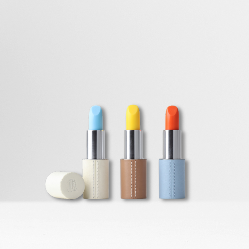 Trio de baumes teintés La Bouche Rouge Dolce Vita – Blu Cielo, Limoncello et Tangerino – présentés dans des écrins en cuir rechargeables blanc, camel et bleu ciel