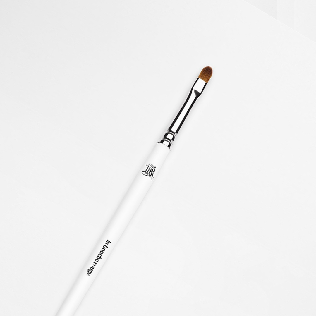 Gros plan pinceau à lèvres la bouche rouge